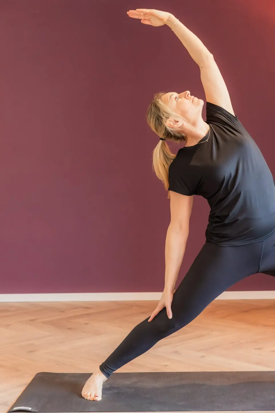 Frau in einer seitlichen Dehnung auf der Matte im YogaStudio Pulheim