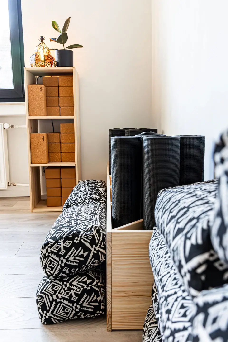 Regal mit Yogamaterial und gemusterten Bolstern im Studio